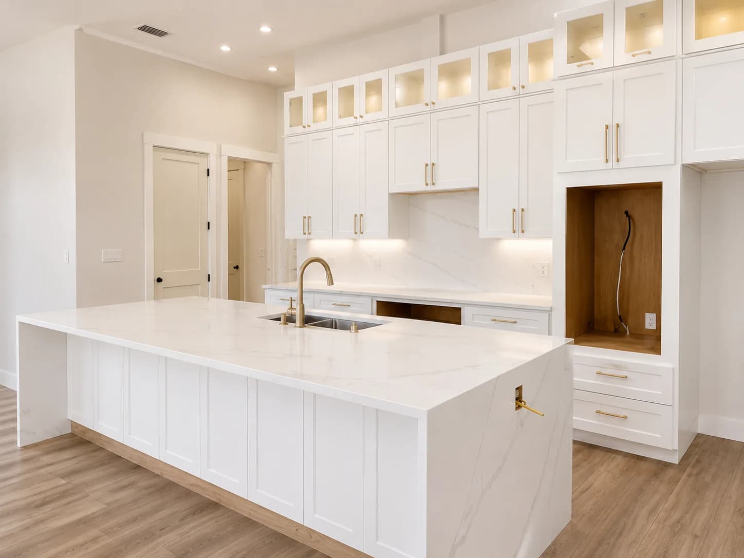 White cabinetry with gold hardware and hidden storage