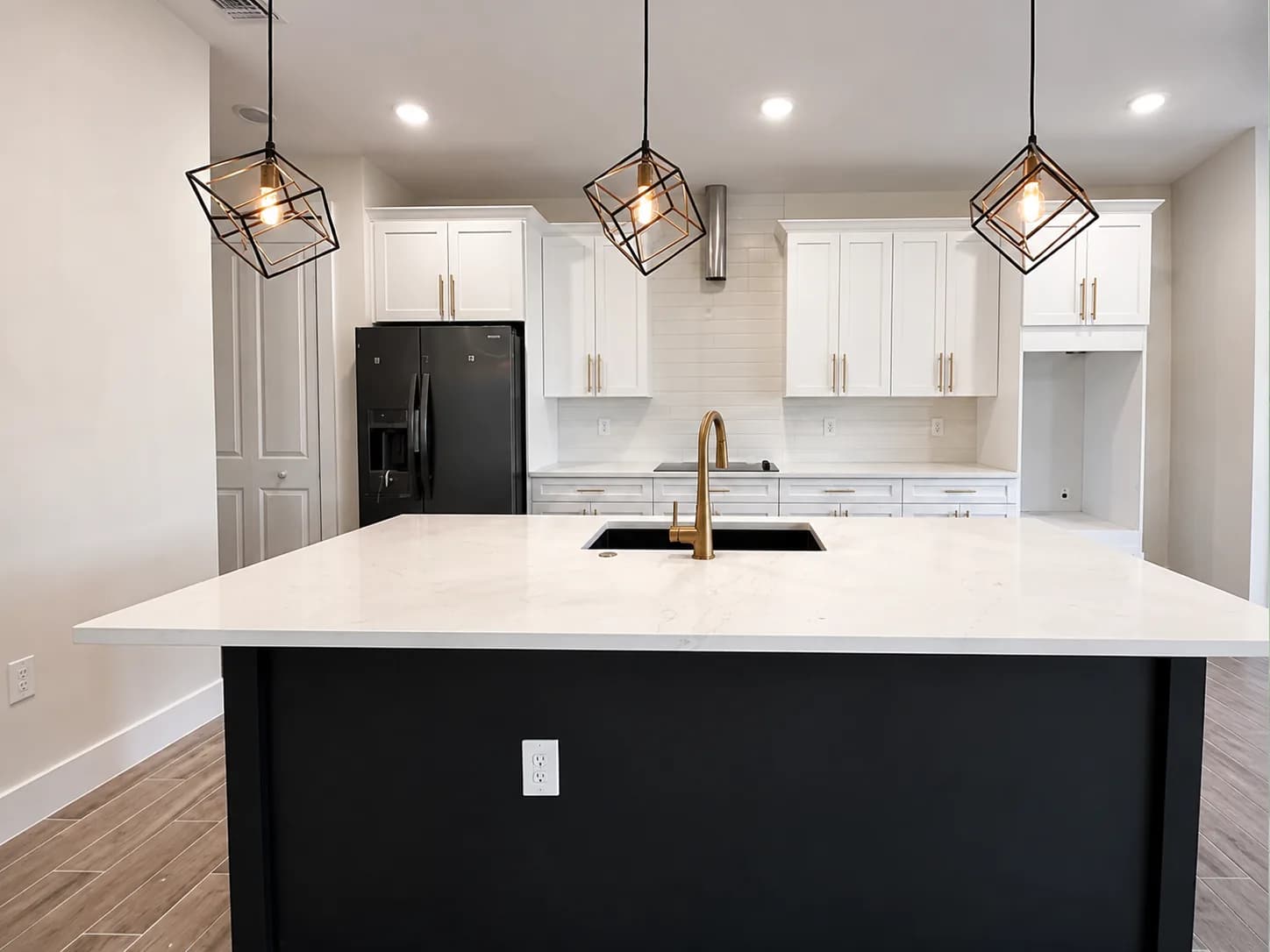 Bright white kitchen with gold hardware and a marble backsplash
